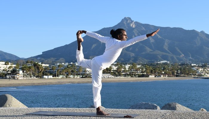 white shirt man doing yoga for pelvic floor