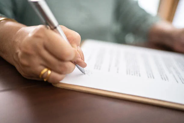 Close up of document being signed by woman