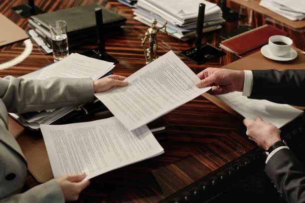 Closeup of hands of unrecognizable lawyers passing documents